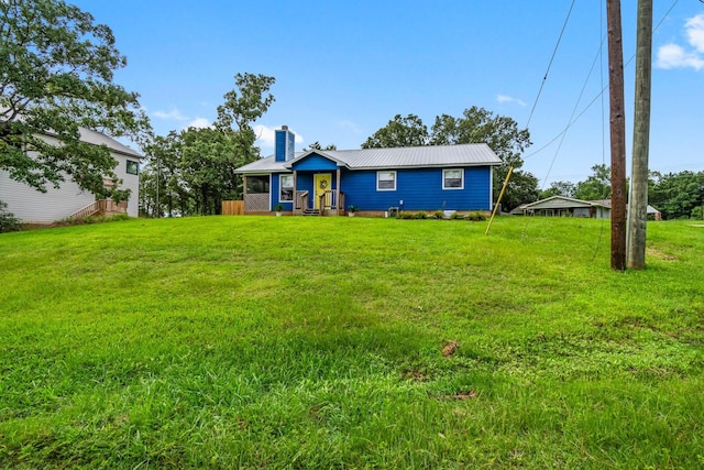 150 Lazy Ln, Livingston, TX 77351 - view of front of home featuring a chimney, a front yard, and a metal roof