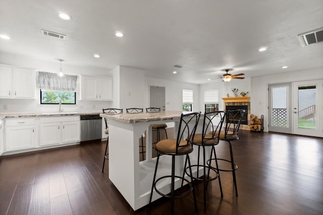 150 Lazy Ln, Livingston, TX 77351 - kitchen featuring stainless steel dishwasher, a kitchen breakfast bar, healthy amount of natural light, dark wood-type flooring, and recessed lighting