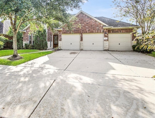23931 Clover Trl, Katy, TX 77494 - view of front facade featuring a garage, concrete driveway, brick siding, and stone siding