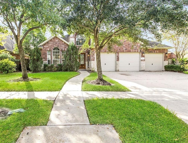 23931 Clover Trl, Katy, TX 77494 - view of front of property with a front yard, brick siding, driveway, and a garage