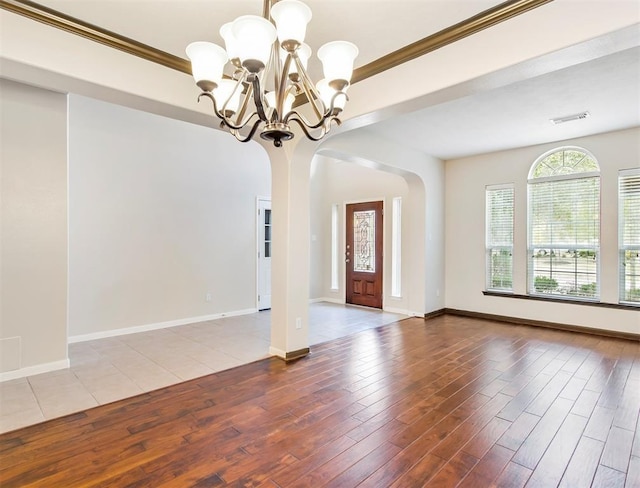23931 Clover Trl, Katy, TX 77494 - empty room with a chandelier, wood finished floors, arched walkways, and ornamental molding