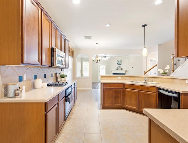 23931 Clover Trl, Katy, TX 77494 - kitchen with appliances with stainless steel finishes, brown cabinetry, tasteful backsplash, pendant lighting, and recessed lighting