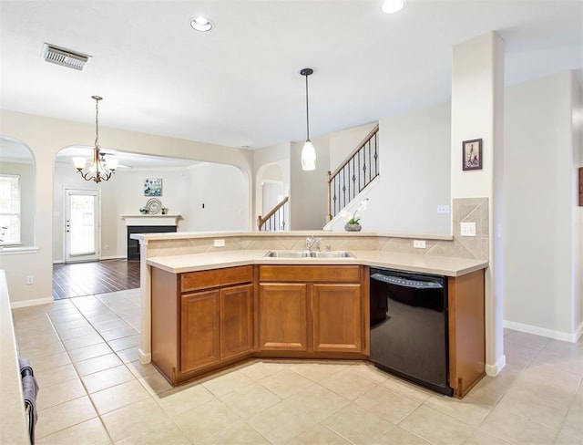 23931 Clover Trl, Katy, TX 77494 - kitchen featuring black dishwasher, arched walkways, light countertops, open floor plan, and brown cabinetry