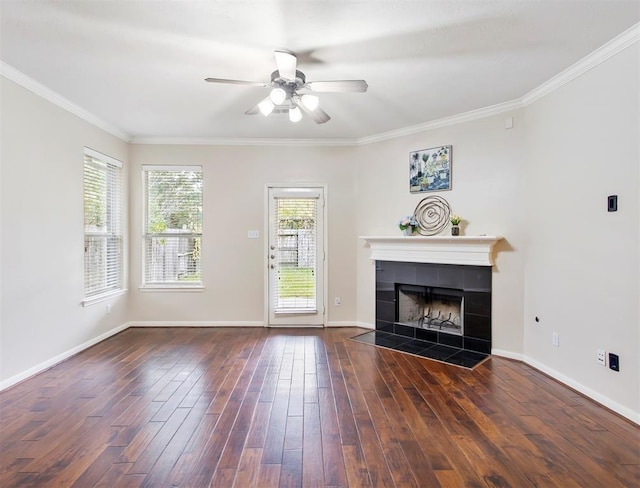 23931 Clover Trl, Katy, TX 77494 - unfurnished living room featuring ceiling fan, dark wood finished floors, a tiled fireplace, and crown molding