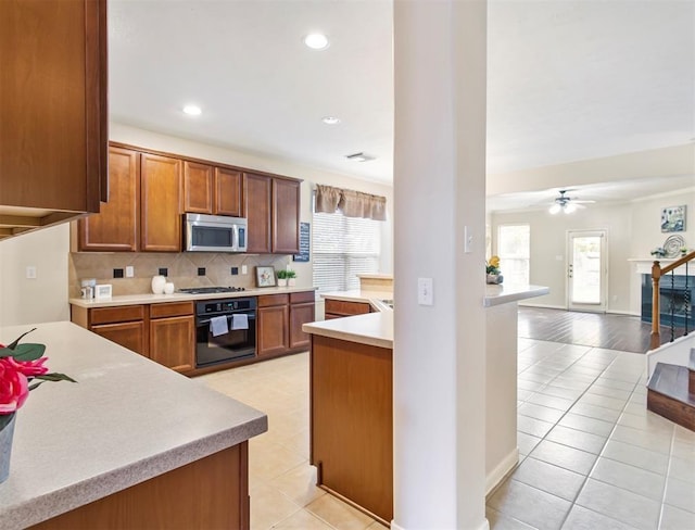 23931 Clover Trl, Katy, TX 77494 - kitchen featuring stainless steel microwave, oven, light tile patterned flooring, gas cooktop, and recessed lighting