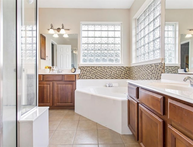 23931 Clover Trl, Katy, TX 77494 - full bathroom featuring a garden tub, healthy amount of natural light, two vanities, and tile patterned floors