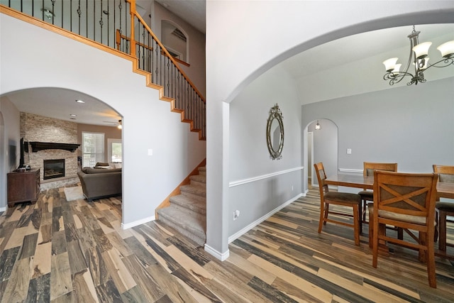 32926 Leafy Oak Ct, Magnolia, TX 77354 - entrance foyer featuring stairs, wood finished floors, arched walkways, a stone fireplace, and a chandelier