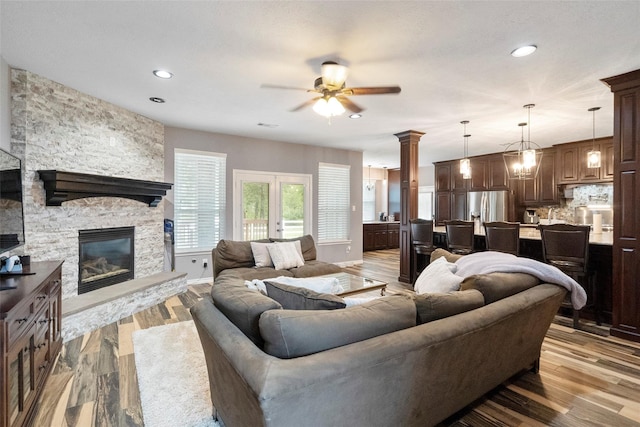 32926 Leafy Oak Ct, Magnolia, TX 77354 - living area featuring ceiling fan, a stone fireplace, light wood-style floors, and recessed lighting