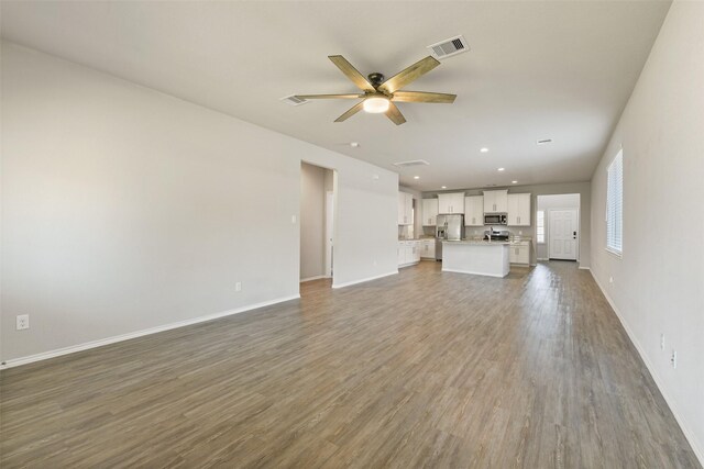 16833 Pink Wintergreen Dr, Conroe, TX 77385 - unfurnished living room featuring a ceiling fan, wood finished floors, and recessed lighting