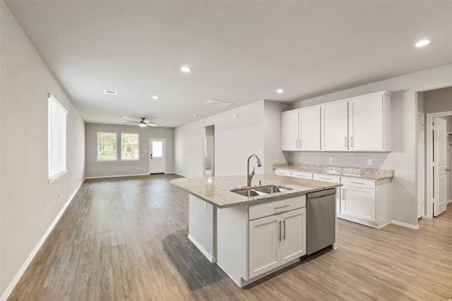 16833 Pink Wintergreen Dr, Conroe, TX 77385 - kitchen featuring stainless steel dishwasher, light wood finished floors, recessed lighting, white cabinetry, and light stone counters