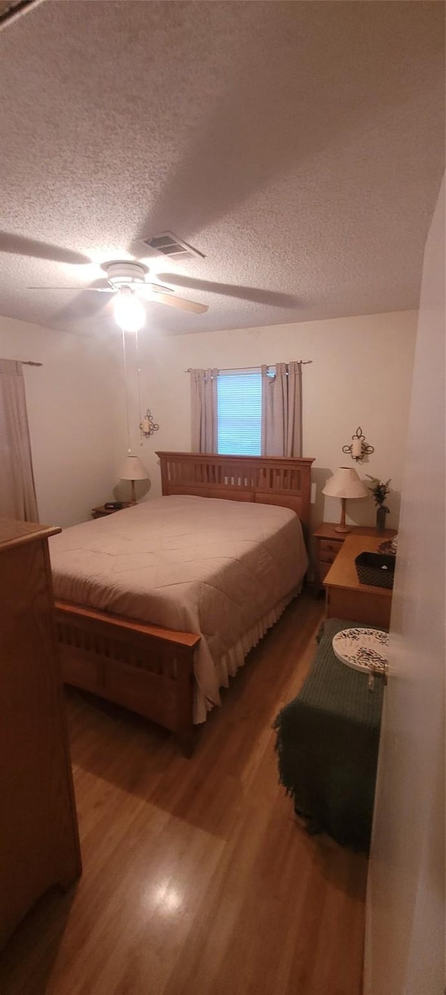 20 Connor Ln, Huntsville, TX 77320 - bedroom featuring wood finished floors, a textured ceiling, and ceiling fan