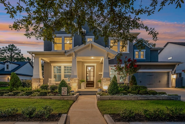 43 W Sawyer Ridge Dr, Spring, TX 77389 - view of front facade featuring stone siding, stucco siding, an attached garage, concrete driveway, and covered porch