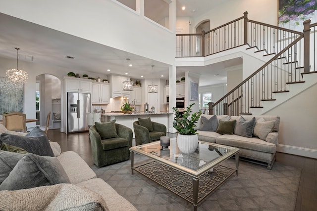 43 W Sawyer Ridge Dr, Spring, TX 77389 - living area featuring arched walkways, dark wood-style flooring, a chandelier, stairway, and recessed lighting
