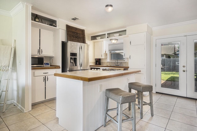 201 E 5th St, Deer Park, TX 77536 - kitchen featuring stainless steel appliances, light tile patterned flooring, crown molding, white cabinetry, and open shelves
