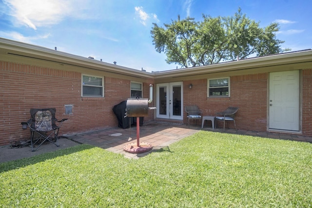 201 E 5th St, Deer Park, TX 77536 - back of property with french doors, brick siding, a lawn, and a patio area