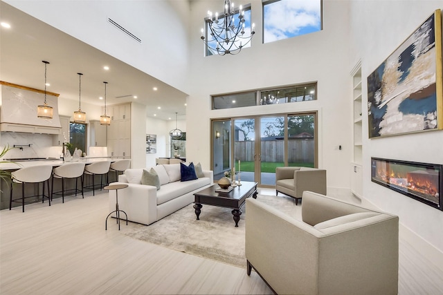 7106 Dearborn St, Houston, TX 77055 - living area with a chandelier, light wood finished floors, a glass covered fireplace, recessed lighting, and a high ceiling