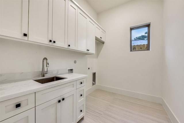 7106 Dearborn St, Houston, TX 77055 - laundry room featuring cabinet space, hookup for an electric dryer, hookup for a washing machine, and light wood finished floors