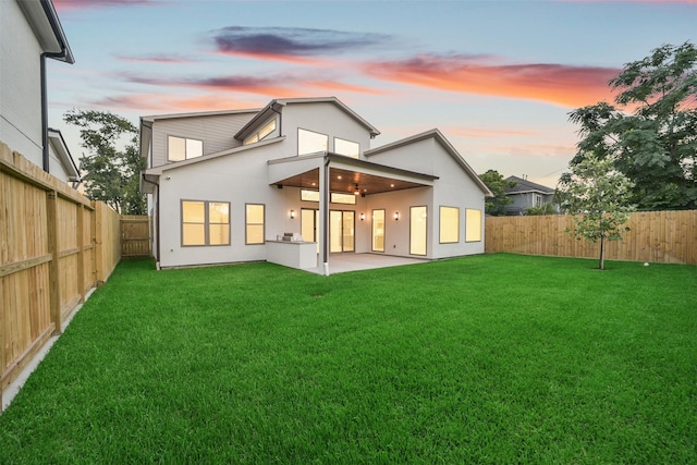 7106 Dearborn St, Houston, TX 77055 - back of property at dusk with a fenced backyard, a patio area, and stucco siding
