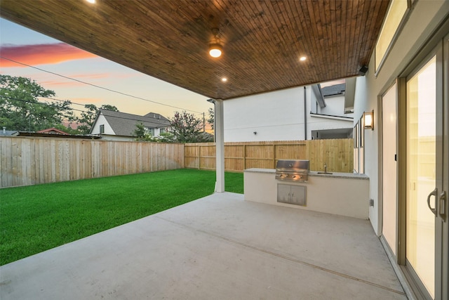 7106 Dearborn St, Houston, TX 77055 - patio terrace at dusk featuring an outdoor kitchen, a patio, and a fenced backyard