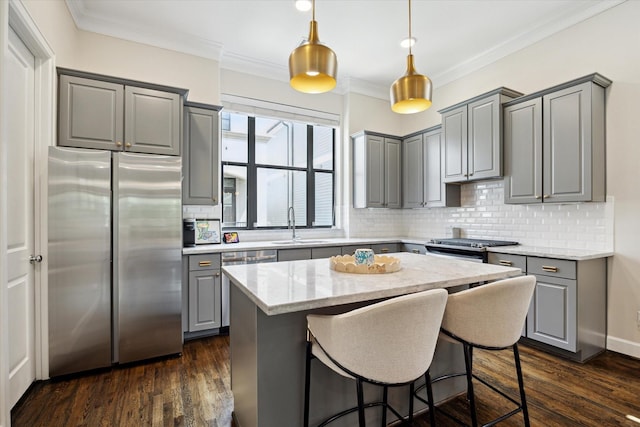 1207 W 24th St Unit A, Houston, TX 77008 - kitchen featuring gray cabinets, appliances with stainless steel finishes, decorative backsplash, ornamental molding, and a kitchen island