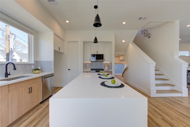 410 N Nagle St, Houston, TX 77003 - kitchen with stainless steel dishwasher, light wood finished floors, tasteful backsplash, light countertops, and recessed lighting
