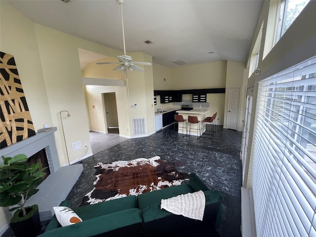 18534 Trail Bend Ln, Houston, TX 77084 - living room featuring a ceiling fan, a fireplace with raised hearth, and high vaulted ceiling