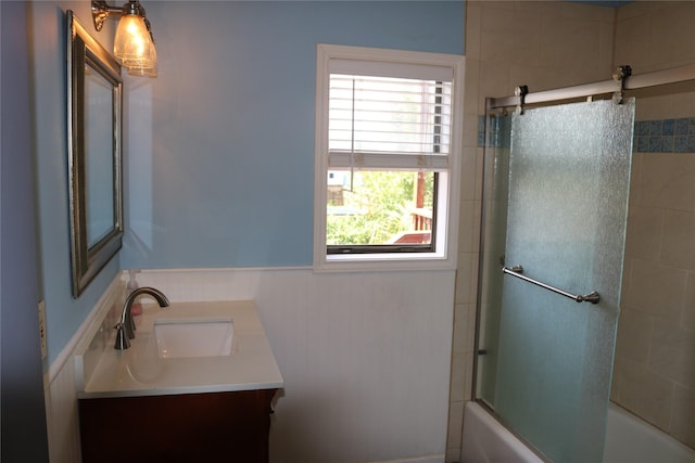16542 John Silver Rd, Jamaica Beach, TX 77554 - bathroom featuring vanity, shower / bath combination with glass door, and a wainscoted wall