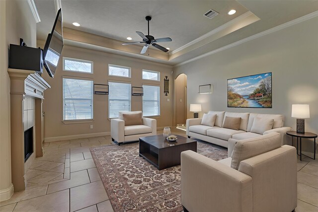 3816 Mystic Cir, Montgomery, TX 77356 - living area featuring a premium fireplace, a ceiling fan, arched walkways, ornamental molding, and a raised ceiling