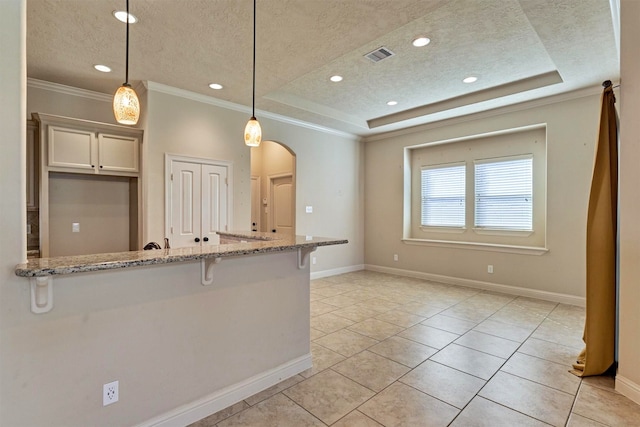 3816 Mystic Cir, Montgomery, TX 77356 - kitchen with a textured ceiling, a kitchen bar, light stone counters, arched walkways, and a raised ceiling