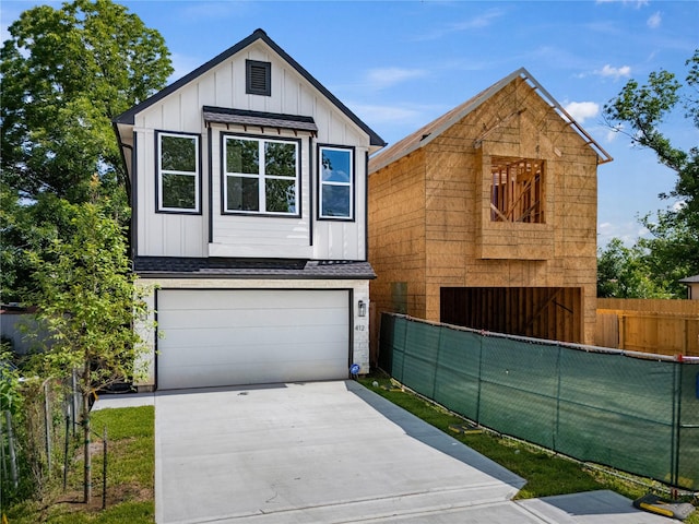 412 E 34th St, Houston, TX 77018 - view of front of house featuring board and batten siding, driveway, a garage, and roof with shingles