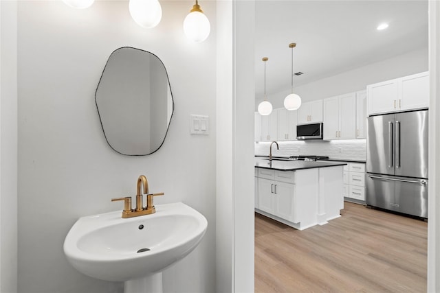 412 E 34th St, Houston, TX 77018 - bathroom featuring wood finished floors, decorative backsplash, and recessed lighting