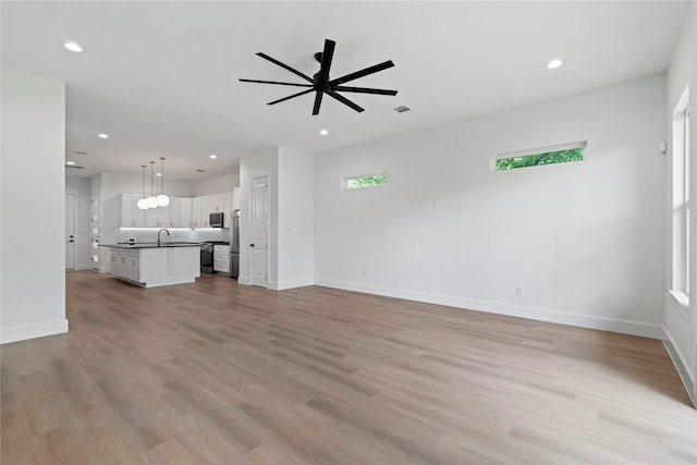 412 E 34th St, Houston, TX 77018 - unfurnished living room with recessed lighting, light wood-style floors, and a ceiling fan