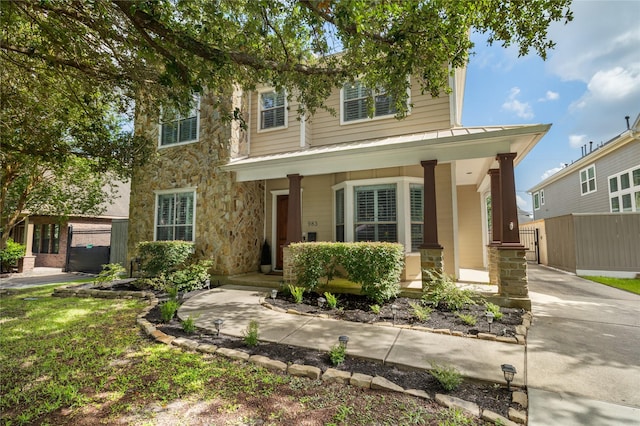 983 W 42nd St, Houston, TX 77018 - view of front of home with a porch, stone siding, a standing seam roof, and a metal roof