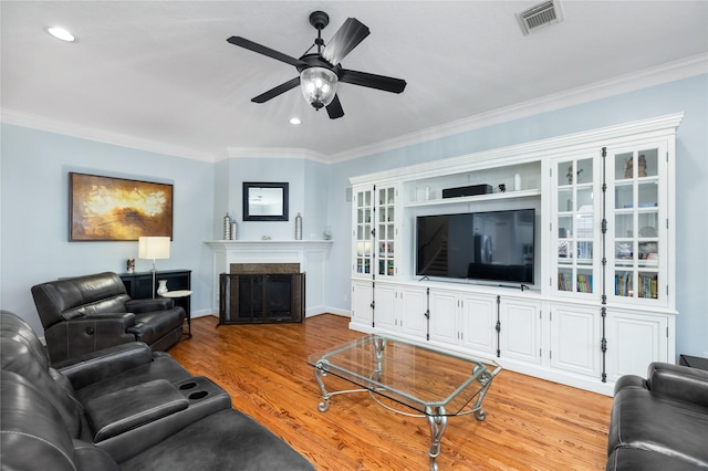 983 W 42nd St, Houston, TX 77018 - living room featuring ceiling fan, light wood-style flooring, a fireplace, crown molding, and recessed lighting