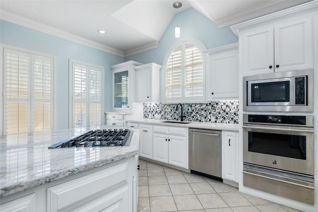 983 W 42nd St, Houston, TX 77018 - kitchen featuring appliances with stainless steel finishes, a warming drawer, light tile patterned floors, decorative backsplash, and white cabinetry