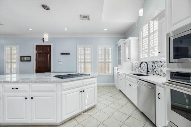 983 W 42nd St, Houston, TX 77018 - kitchen with stainless steel appliances, white cabinets, decorative light fixtures, decorative backsplash, and light tile patterned floors
