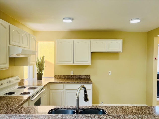 11530 Bellerive Dr, Houston, TX 77072 - kitchen with white range with electric cooktop, under cabinet range hood, white cabinetry, and dark stone countertops