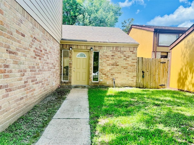 11530 Bellerive Dr, Houston, TX 77072 - property entrance with roof with shingles, brick siding, and a gate
