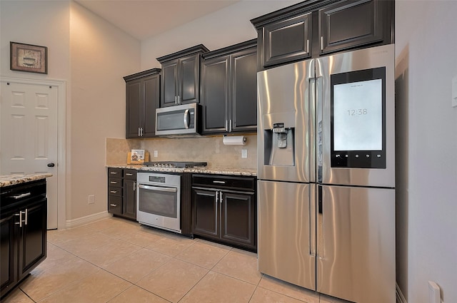4227 Lodge Ranch Ct, Fulshear, TX 77441 - kitchen featuring stainless steel appliances, dark cabinetry, and light tile patterned flooring