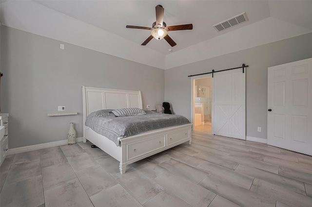 4227 Lodge Ranch Ct, Fulshear, TX 77441 - bedroom with a barn door, lofted ceiling, a ceiling fan, connected bathroom, and wood tiled floors