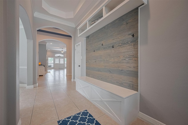 4227 Lodge Ranch Ct, Fulshear, TX 77441 - mudroom with arched walkways, crown molding, wood walls, and light tile patterned floors