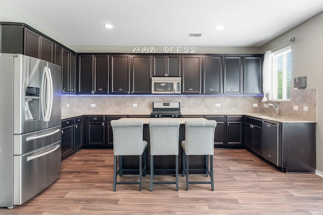 15915 Mountain Willow Way, Cypress, TX 77429 - kitchen featuring appliances with stainless steel finishes, a kitchen island, recessed lighting, light countertops, and light wood-style floors