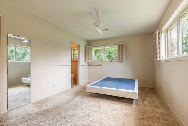 122 Blossom St, Lake Jackson, TX 77566 - unfurnished bedroom featuring multiple windows, carpet floors, ensuite bath, and a ceiling fan