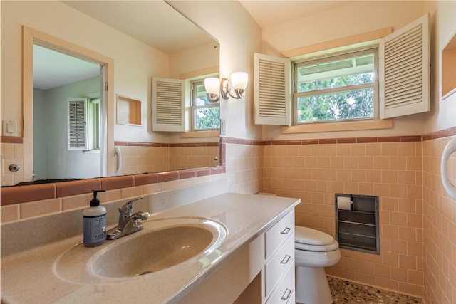 122 Blossom St, Lake Jackson, TX 77566 - bathroom with tile walls, plenty of natural light, vanity, and wainscoting