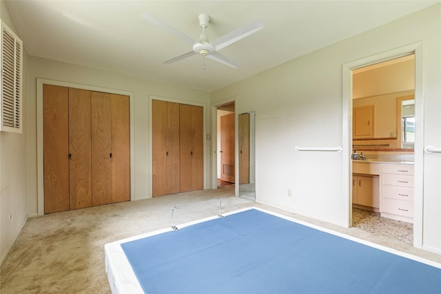 122 Blossom St, Lake Jackson, TX 77566 - unfurnished bedroom with multiple closets, light colored carpet, connected bathroom, and a ceiling fan