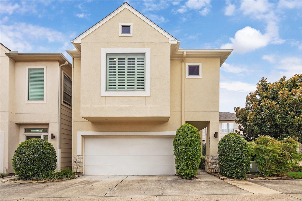 3904 Center St, Houston, TX 77007 - view of property with stucco siding, an attached garage, and concrete driveway