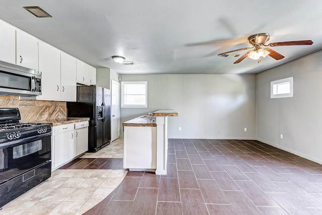 6763 Glen Rock Dr, Houston, TX 77087 - kitchen featuring black appliances, a ceiling fan, white cabinets, and tasteful backsplash