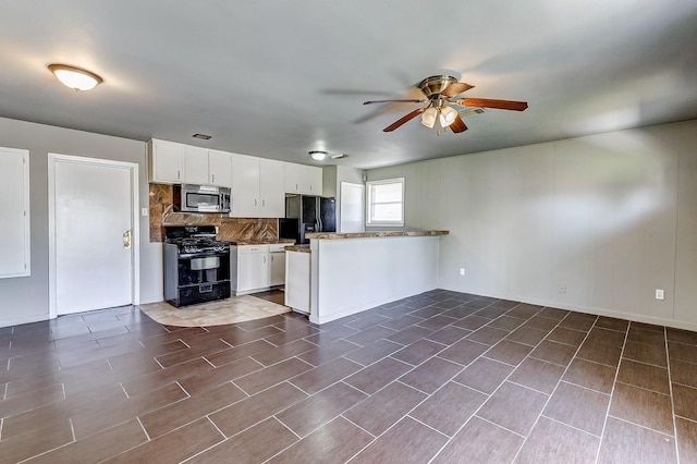 6763 Glen Rock Dr, Houston, TX 77087 - kitchen featuring black appliances, a peninsula, ceiling fan, tasteful backsplash, and white cabinets