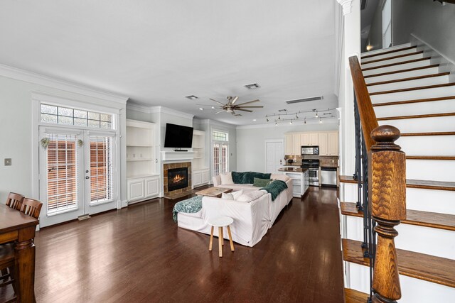 2111 Beall St, Houston, TX 77008 - living room featuring stairs, dark wood-type flooring, crown molding, a fireplace, and healthy amount of natural light