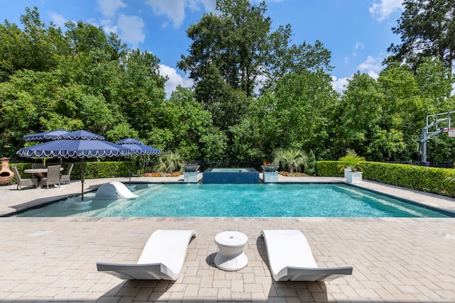 8550 Tombron Grove Rd, Magnolia, TX 77354 - view of pool with a patio area, a pool with connected hot tub, and view of scattered trees